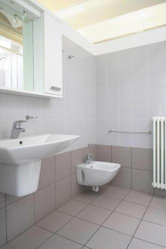 a white bathroom with a sink and a toilet at APPARTAMENTO MODERNO con parcheggio gratuito di fronte in Lecco