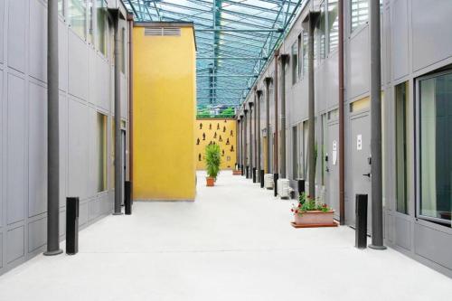 an empty hallway in a building with a yellow wall at APPARTAMENTO MODERNO con parcheggio gratuito di fronte in Lecco