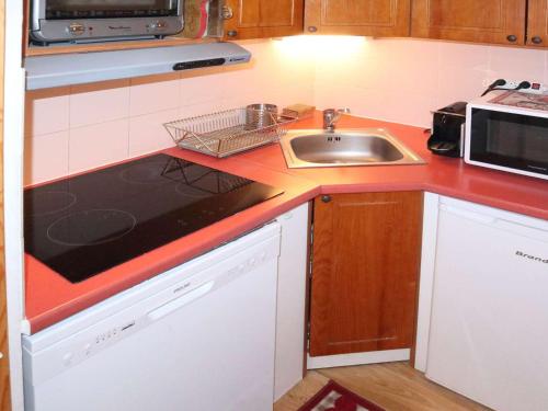 une cuisine avec un évier et un plan de travail dans l'établissement Duplex 4 chambres, piscine chauffée, sauna, skis aux pieds - Les Orres - FR-1-322-381, aux Orres