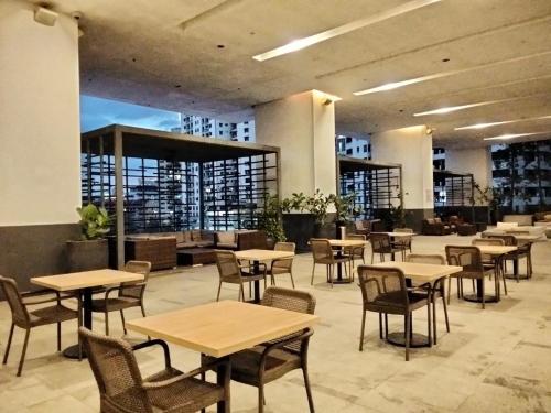 a restaurant with tables and chairs in a building at CozyNest Suites Bukit Bintang in Kuala Lumpur