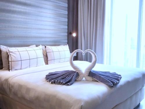 two swans made out of towels on a bed at CozyNest Suites Bukit Bintang in Kuala Lumpur
