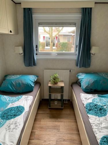 a small room with two beds and a window at Lieblingsplatz Renesse, Camping Siblu de Oase in Renesse