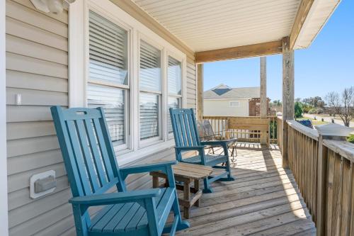 twee blauwe stoelen op de veranda van een huis bij Nadines Nest in Kitty Hawk