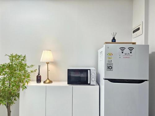 a microwave sitting on a counter next to a refrigerator at Shinhwahouse 5 mins from Seoul Station in Seoul