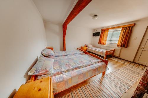 a bedroom with two beds and a window at Pensiunea Patakparti in Praid