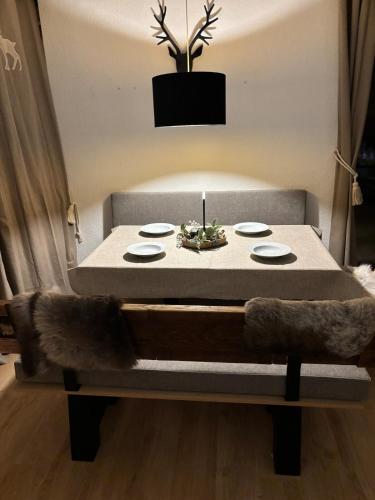 a table with plates and a plant on top of it at Charming apartment Berggeweih Lodge at Zwölferkogel in Hinterglemm in Größing
