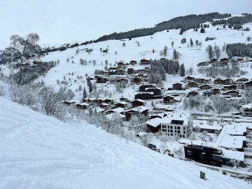 a village covered in snow on a snowy hill at Charming apartment Berggeweih Lodge at Zwölferkogel in Hinterglemm in Größing