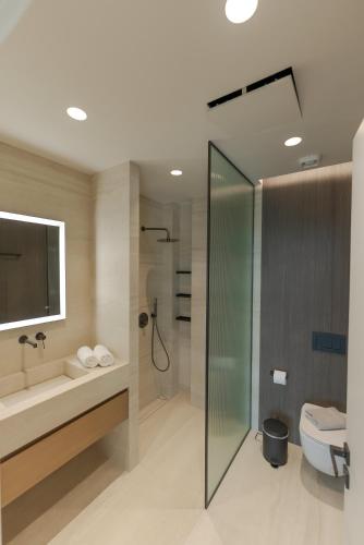 a bathroom with a shower and a toilet and a sink at Theros Kourouta Boutique Hotel in Kourouta