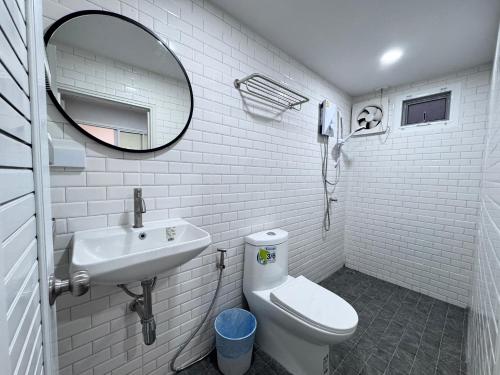 a bathroom with a sink and a toilet and a mirror at Wind in the Wild Khao Yai in Nakhon Ratchasima