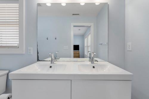 a white bathroom with two sinks and a mirror at Now Youre Cookin in Duck