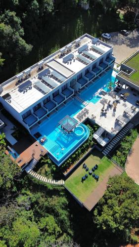 an aerial view of a building with a swimming pool at Collegare Hotel in Capitólio