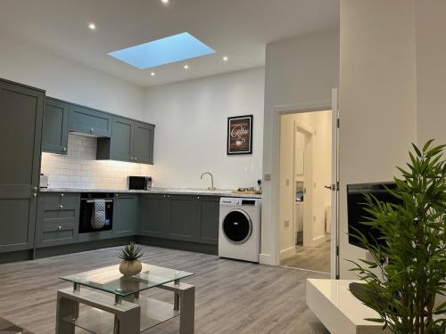 a kitchen with green cabinets and a washer at The Coastal Getaway in Isle of Wight