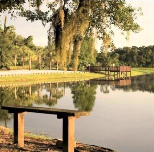 un banco sentado frente a un cuerpo de agua en Amazing Retreat at Lake Berkley, en Kissimmee