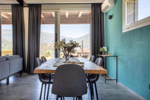 a dining room with a table and chairs and mountains at Villa Vento in Colico