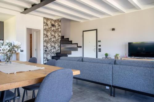 a living room with a table and blue chairs at Villa Vento in Colico