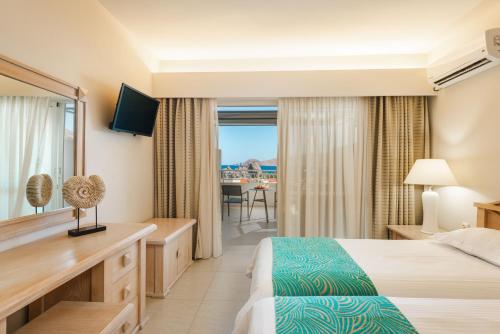 a hotel room with a bed and a balcony at Halotels Porto Myrina in Myrina