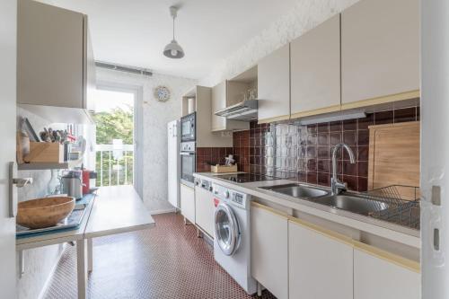 a kitchen with a sink and a washing machine at LE PANORAMIQUE - Face mer - Wifi in Pornichet