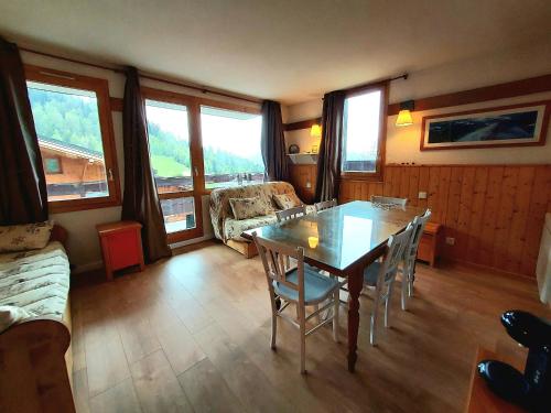 un salon avec une table, des chaises et un canapé dans l'établissement Charmant 2P rénové avec balcon, proche commerces, casier à ski et parking, Plagne 1800 - FR-1-351-160, à La Plagne Tarentaise