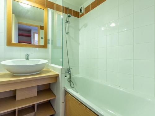 une salle de bain avec un lavabo et une baignoire dans l'établissement Charmant 2P rénové avec balcon, proche commerces, casier à ski et parking, Plagne 1800 - FR-1-351-160, à La Plagne Tarentaise