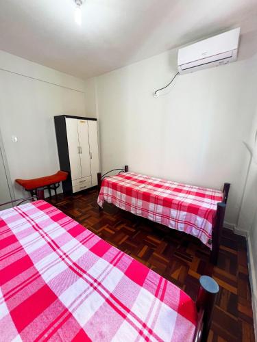 a room with two beds and a red and white blanket at Amplo apê em bairro nobre in Atalaia Nova