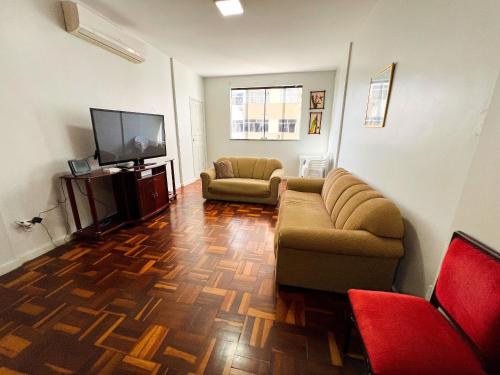 a living room with a couch and a flat screen tv at Amplo apê em bairro nobre in Atalaia Nova