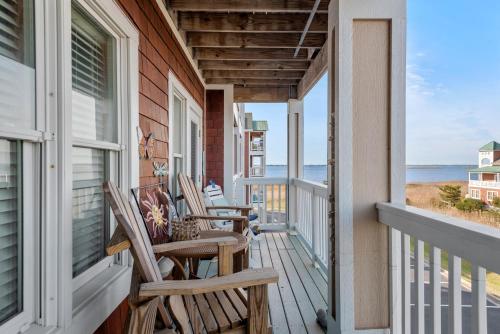 Un porche con sillas y vista al mar. en OBX Dream, en Nags Head