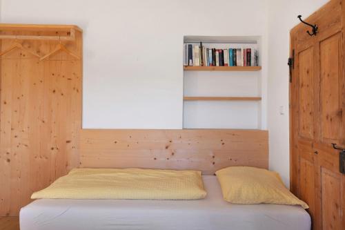 a bed with a wooden headboard in a bedroom at Rielingerhof in Collalbo