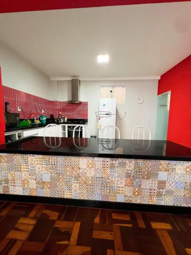 a kitchen with a black counter top with a refrigerator at Amplo apê em bairro nobre in Atalaia Nova