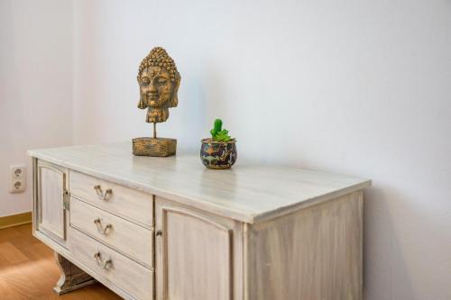 a wooden dresser with a statue of a head on it at Gästehaus Ziegler in Neuenkirchen