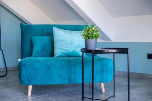 a blue couch with a table with a potted plant on it at Villa Vento in Colico