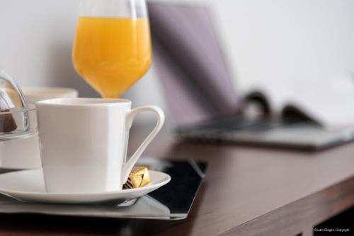 a glass of orange juice next to a cup of coffee at Priska Med Luxury Rooms in Split