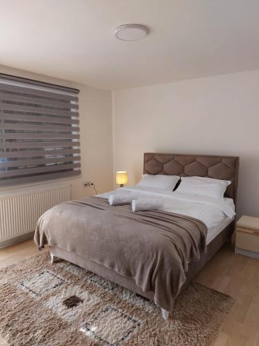 una camera da letto con un letto grande e una finestra di R Apartments a Paraćin