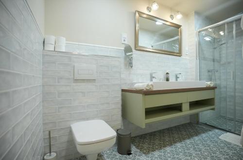 a bathroom with a toilet and a sink and a mirror at Nomad Hotel & Glamping in Noszvaj