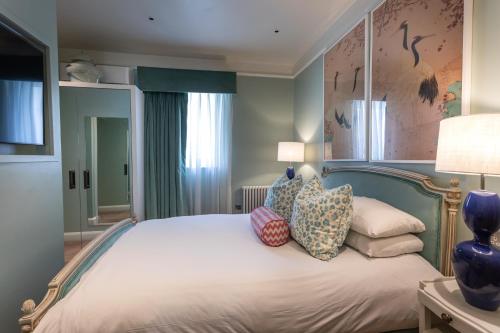 a bedroom with a large bed with pillows on it at Roslin Beach Hotel in Southend-on-Sea