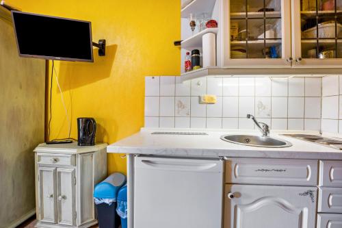 a kitchen with a sink and a tv on the wall at Gästehaus Ziegler in Neuenkirchen