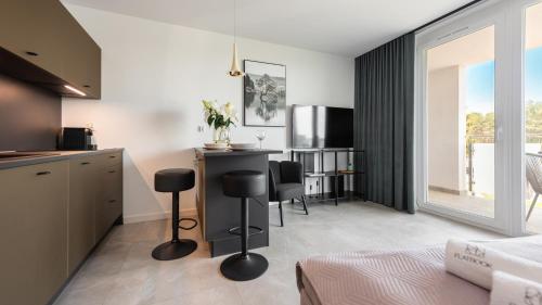Una cocina con una mesa y sillas en una habitación. en Flatbook Apartamenty - Sztutowo Baltic Garden z Basenem i Parkingiem, en Sztutowo