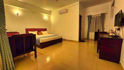 a hotel room with a bed and a television at BOB Green Aura in Sultan Bathery