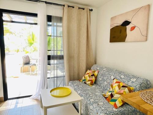 a living room with a couch and a table and a window at F3Sun CASA JACOB - 2 BR, Green Oasis, Costa Calma, Fuerteventura in Costa Calma
