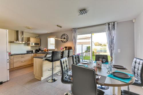 a kitchen and dining room with a table and chairs at Le Dôme - Piscine - Parking - Jardin in Commequiers