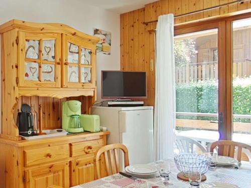 une salle à manger avec une table et une télévision ainsi qu'une cuisine dans l'établissement Appartement 2 pièces + cabine, proche pistes et centre, parking inclus - Le Grand-Bornand - FR-1-241-212, au Grand-Bornand