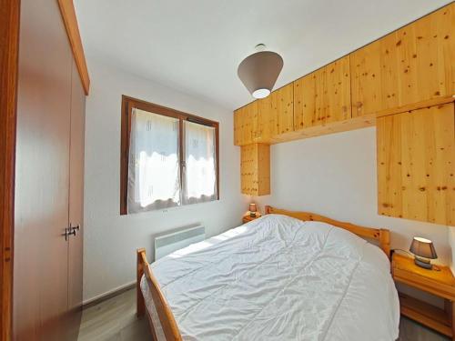 une chambre avec un lit et une fenêtre dans l'établissement Appartement 2 pièces + cabine, proche pistes et centre, parking inclus - Le Grand-Bornand - FR-1-241-212, au Grand-Bornand