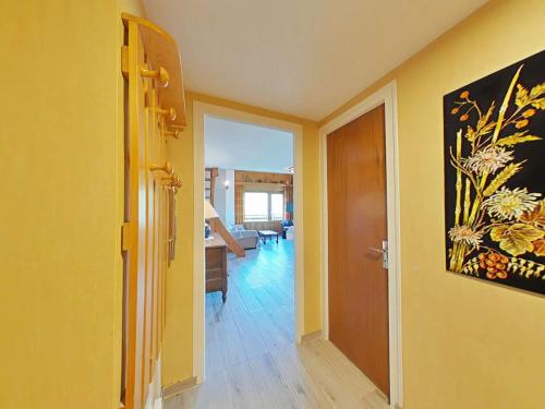 un couloir avec une porte et un salon aux murs jaunes dans l'établissement Appt 3 pièces avec mezzanine, 6 couchages, proche commerces et pistes, parking couvert - FR-1-241-189, au Grand-Bornand