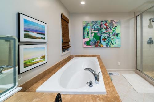 a bath tub in a bathroom with paintings on the wall at 3145 Green Heron Court in Seabrook Island