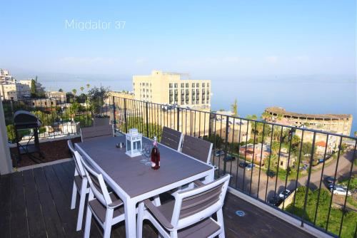 Una mesa y sillas en un balcón con vista. en Yalarent Panoramic View Sea of Galilee, en Tiberíades