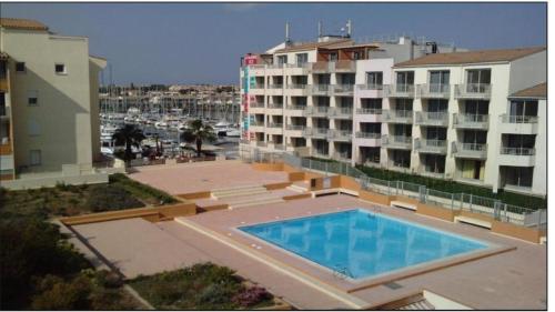 une grande piscine devant un immeuble dans l'établissement Tout confort en première ligne, au Cap d'Agde