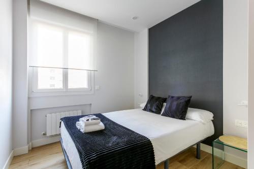 a bedroom with a bed with a black accent wall at Epalza apartment by People Rentals in Bilbao