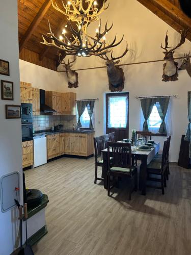 a kitchen and dining room with a dining table and antlers on the wall at Zselici VadVirág Vendégház 