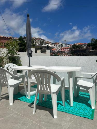 a table and chairs and an umbrella on a patio at Casa Bamboo central Funchal Villa in Funchal