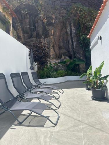 a row of chairs lined up against a wall at Casa Bamboo central Funchal Villa in Funchal