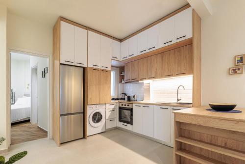 a kitchen with white cabinets and a washer and dryer at Rotunda Living Nr12 in Thessaloniki